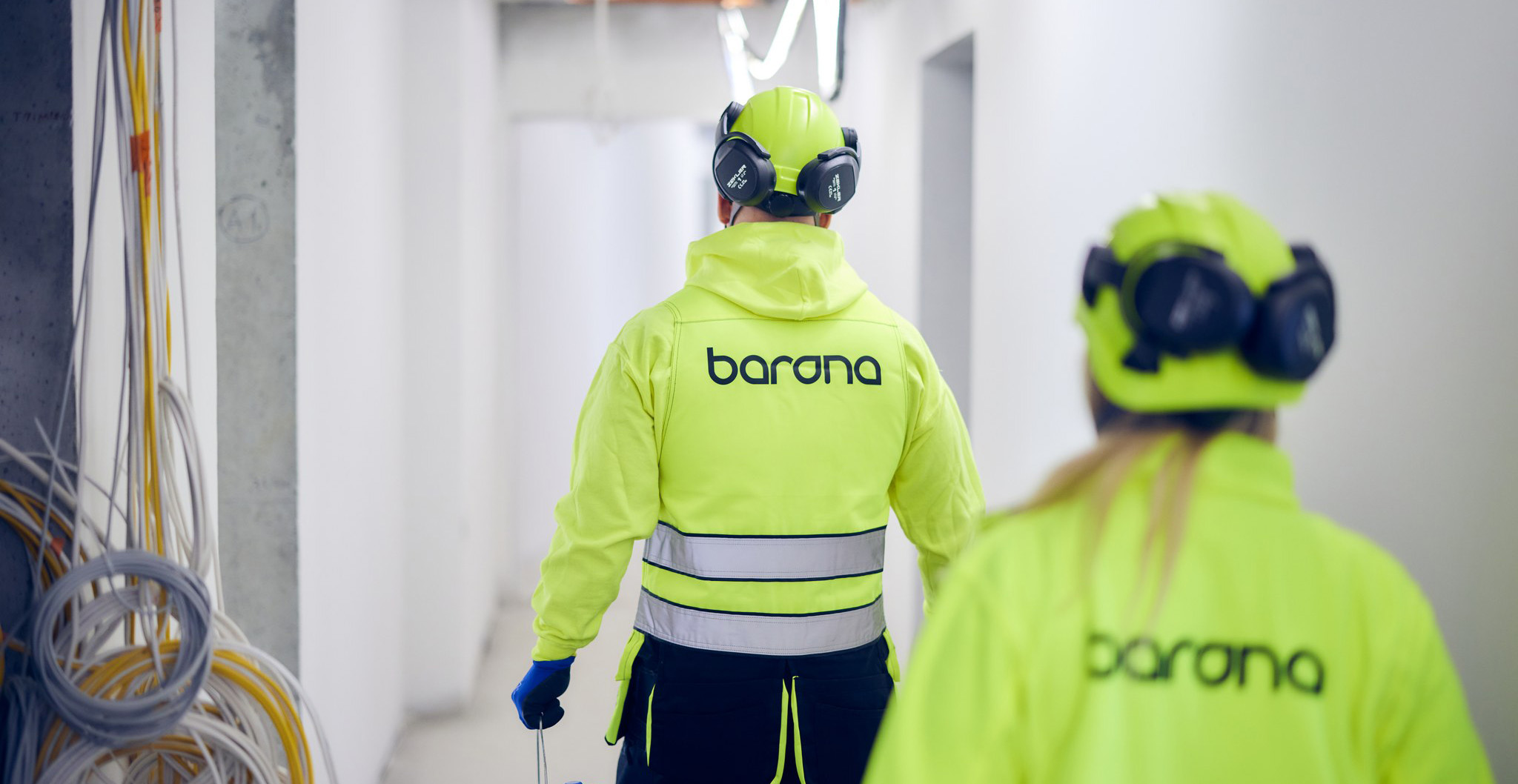 Bilde av en bygningsarbeider som går bort fra kameraet med teksten Barona bak på jakken.